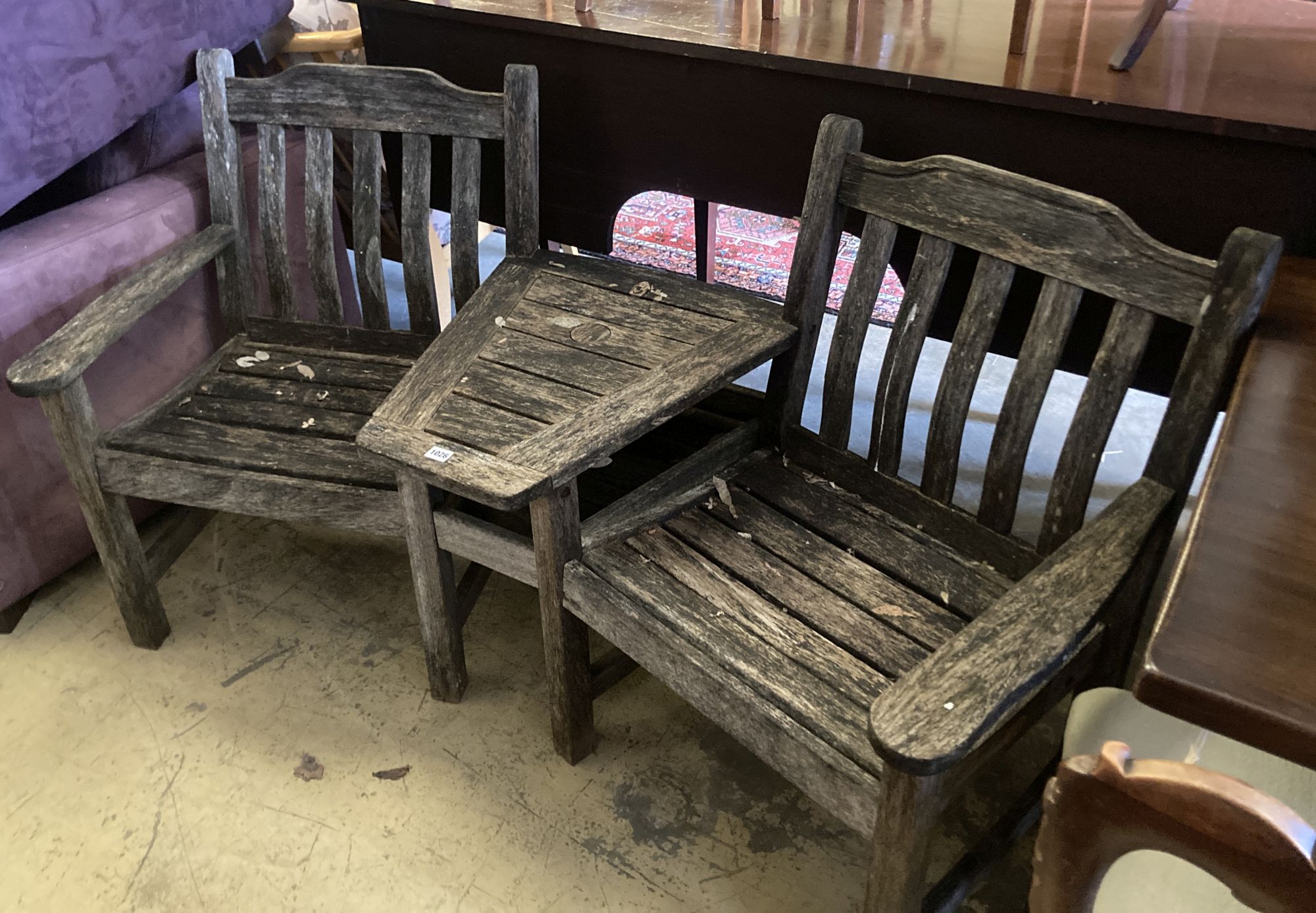 A weathered teak garden conversation seat, length 163cm, depth 80cm, height 86cm, together with a Gloster rectangular teak low garden t